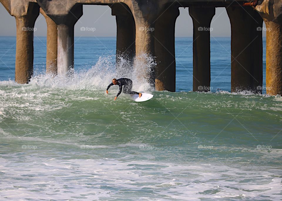 Surfer making the big waves look easy in Manhattan Beach, CA.