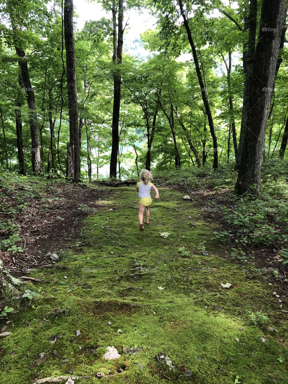 Excitedly running through the woods to get to the lake on a hot summer day 