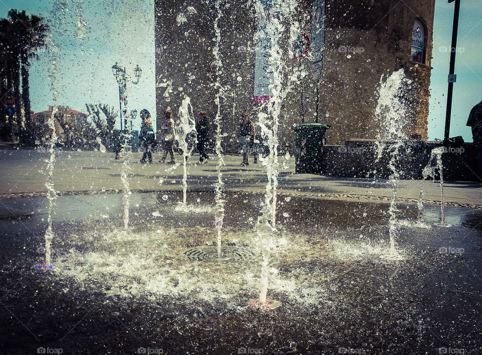 water in motion: Close up of water splash from a fountain with colored light