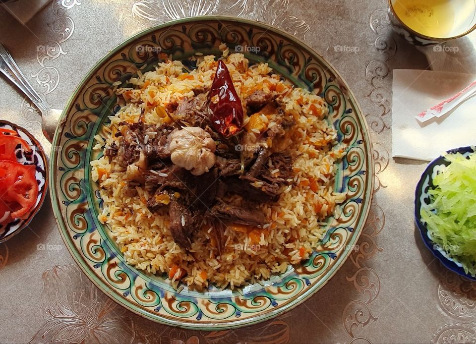 Uzbek pilaf with lamb and hot peper in a traditional plate