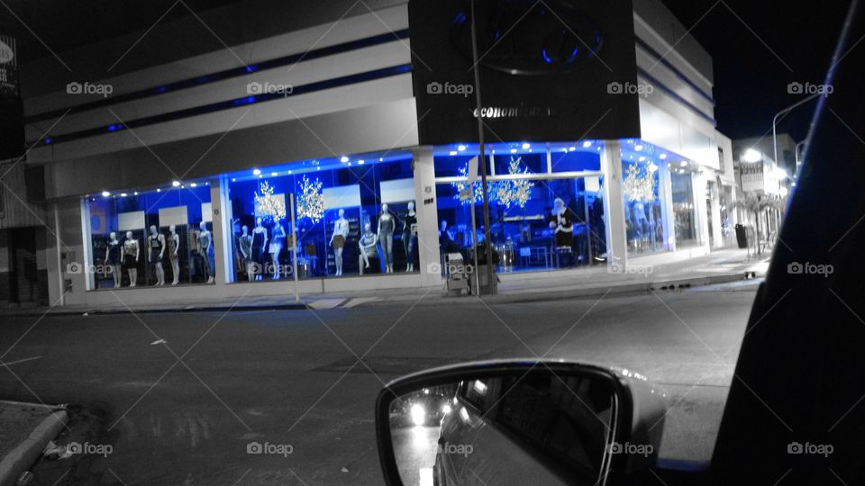 Cidade à noite. Loja de vestuário, decoração Natalina.