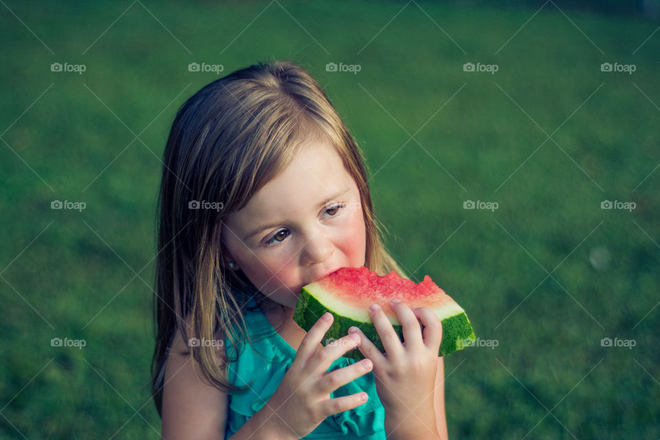 Young Girl Eating Watermelon Outside at Park 4