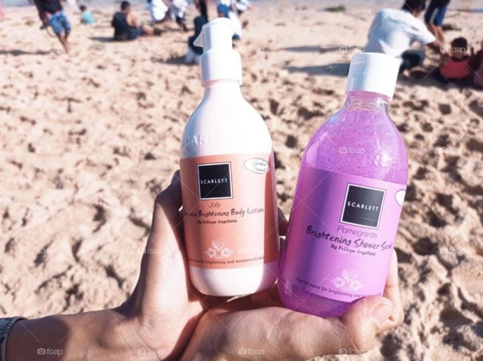 Bottle of skin lightening cream in hand