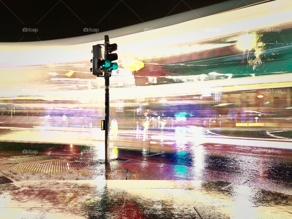 Traffic light at cross roads with light trails in background