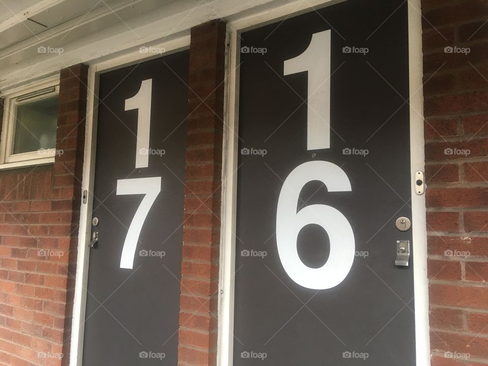 Two adjacent numbered doors at Elizabeth Newcomen House off Crosby Row, Southwark, with oversized white numbers. Passed in Spring.