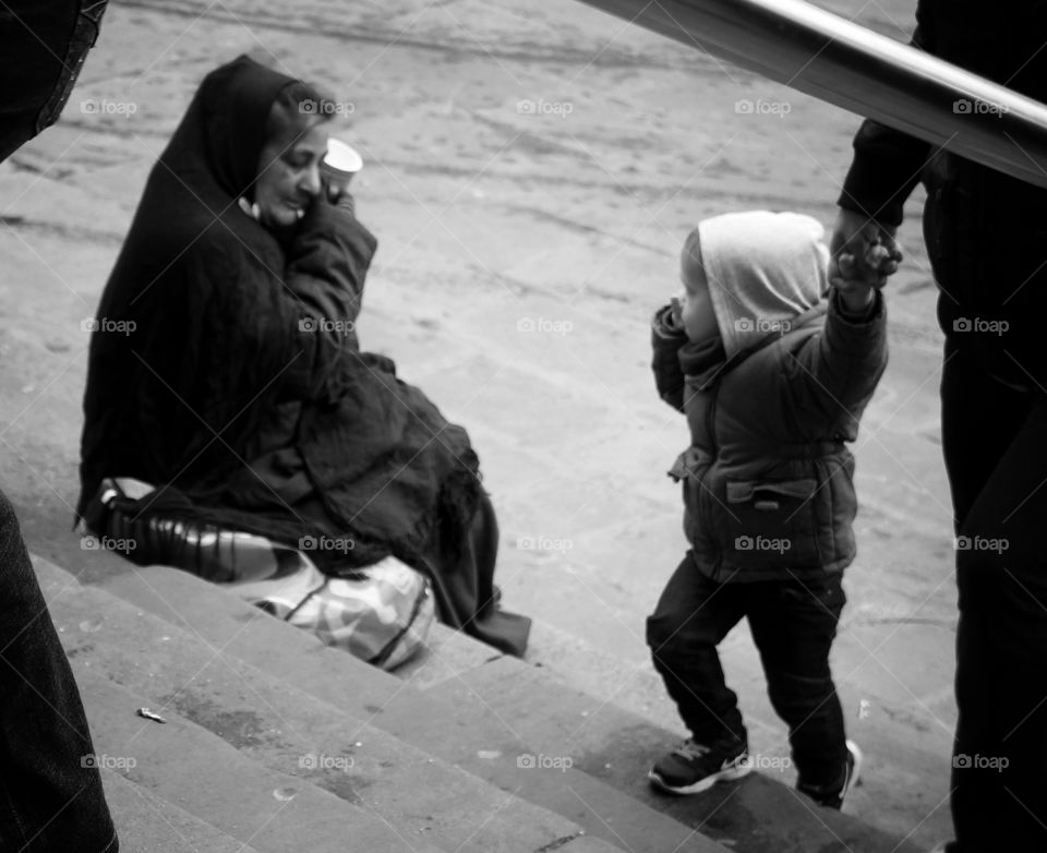 A look to reality. The way that little kid look at the beggar says a lot.