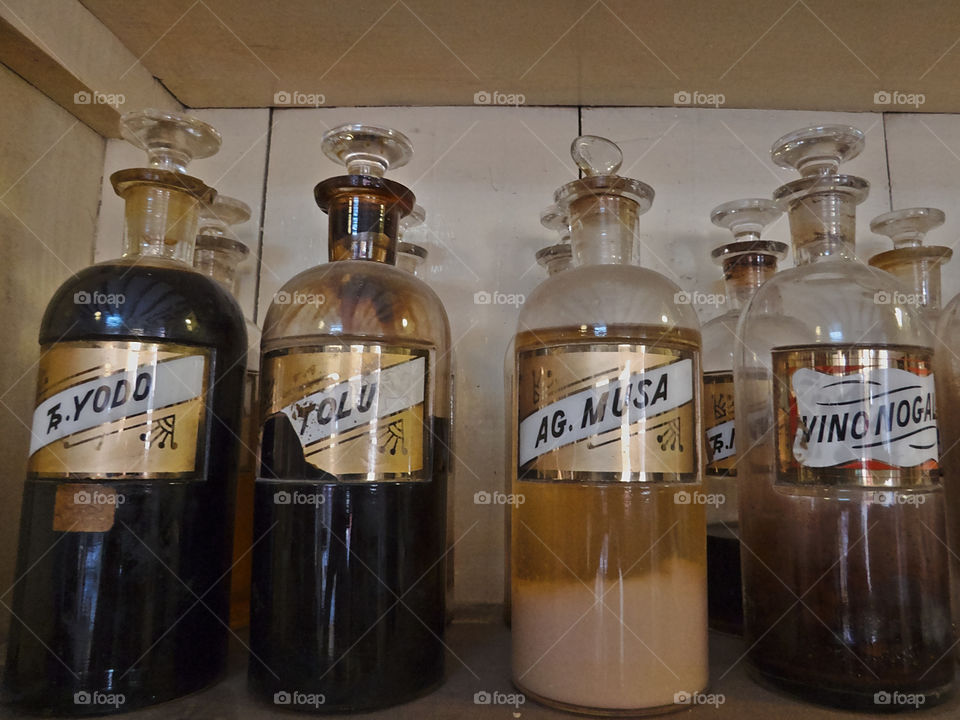 Close-up of antique pharmaceutical flasks with natural and synthetic chemicals labeled in Spanish in old drugstore in San Miguel de Allende, Guanajuato, Mexico