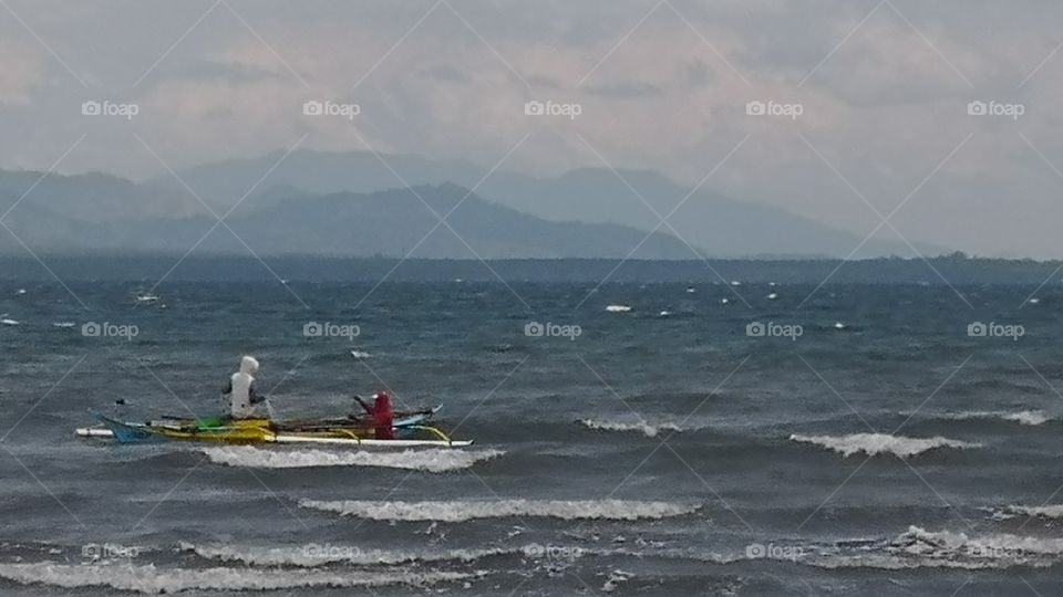 Fisherman on a small boat at the sea