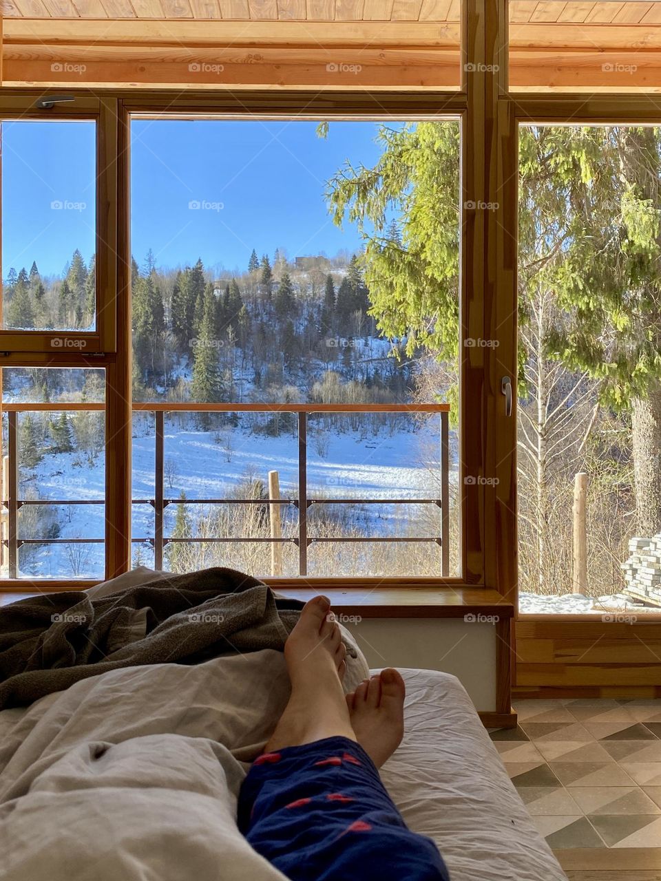 Photo of a sunny morning in the Carpathians in Ukraine. View from my window of winter mountains and snow-covered trees. Watching this live takes your breath away. The photo was taken on a phone.