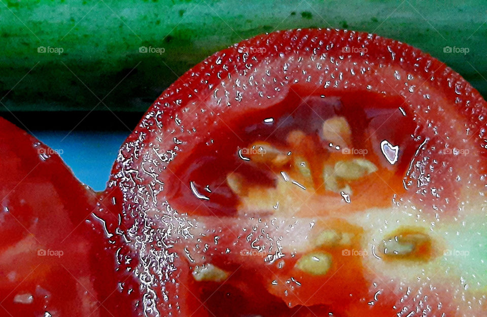Fresh and juicy sliced tomato with cucumber captured in natural lights.