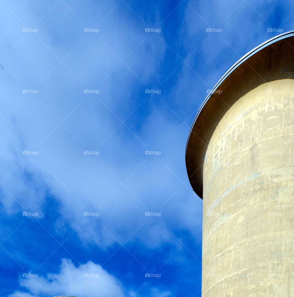 Low angle view of built structure against cloudy sky by day.
