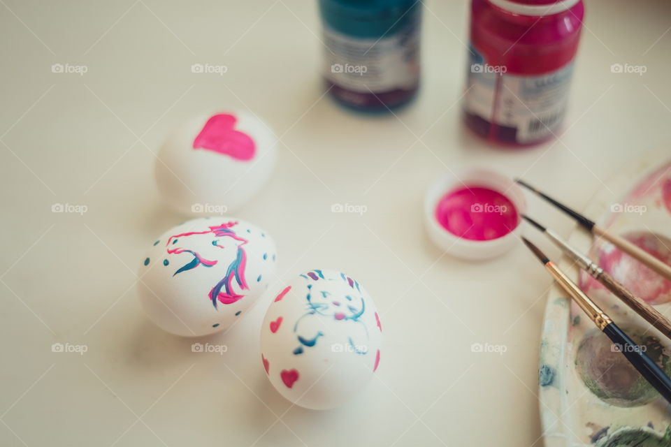 painting the Easter egg at white desk in daylight 