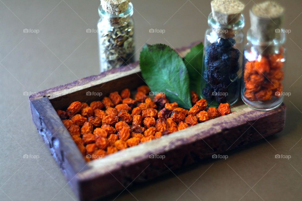 a rectangular small box filled with dried rowan. next to it are two vials with berries and dried grass