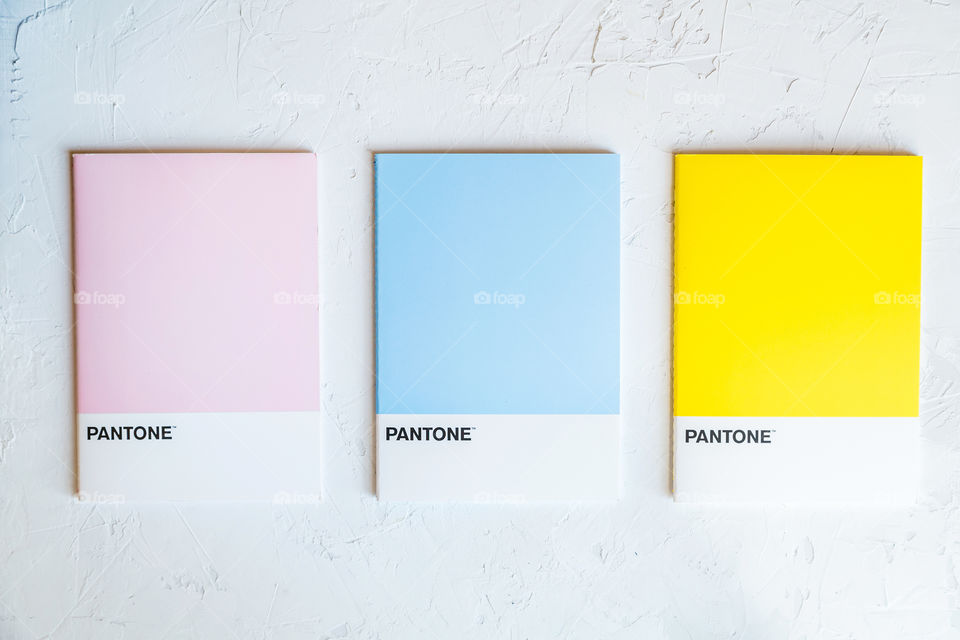 Pink, blue, yellow colors from Pantone on gray concrete background 