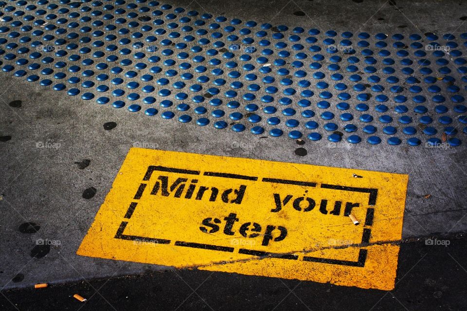 A "mind your step" sign of the ground of a train station in Australia 
