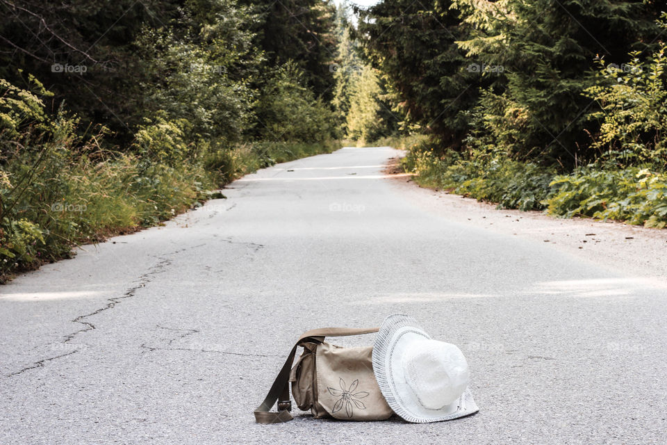 On the road, empty road, a bag and a hat on the road