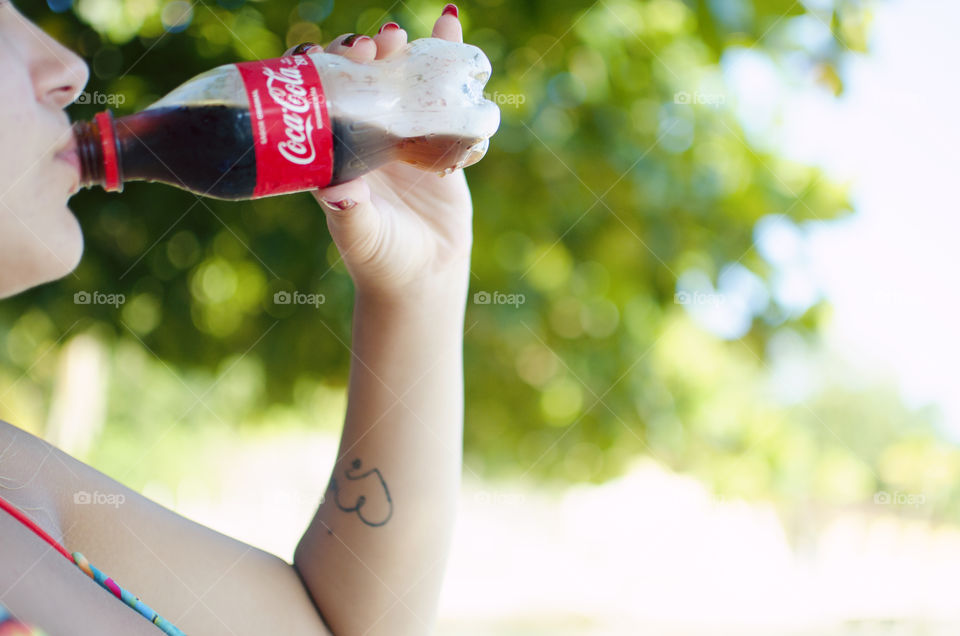 Woman drinking Coke at the beach