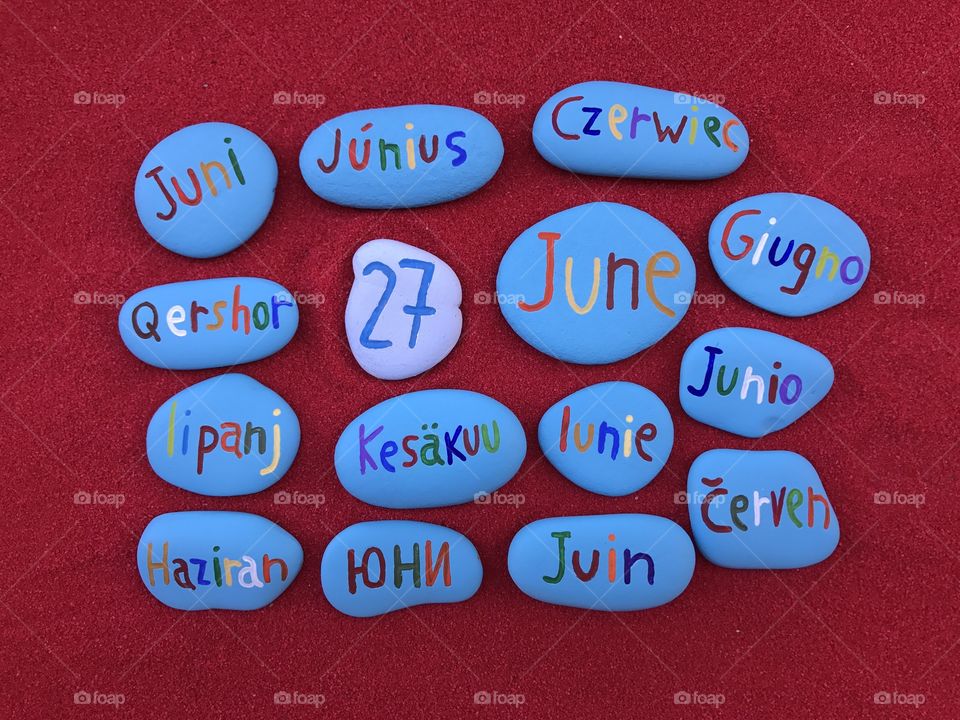 27 June, calendar date in many languages with colored stones and red background 