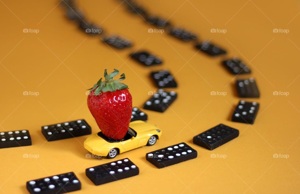 Playing with toy car, strawberry and domino