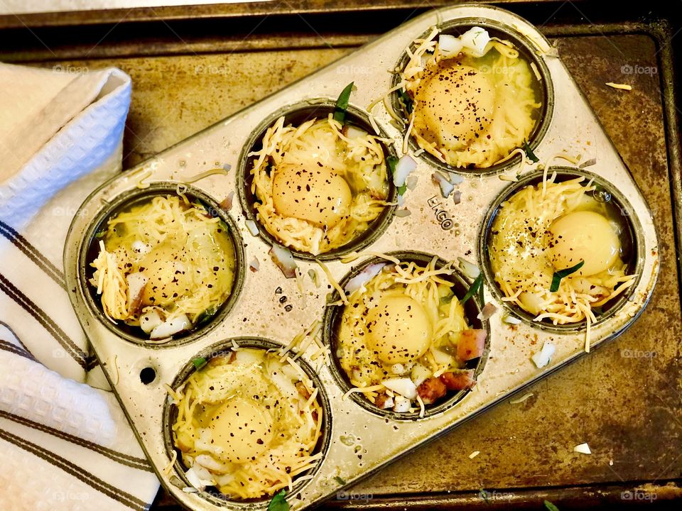 Eggs for breakfast, bird in a nest. Muffin tin with shredded potato, cheddar cheese and egg to bake