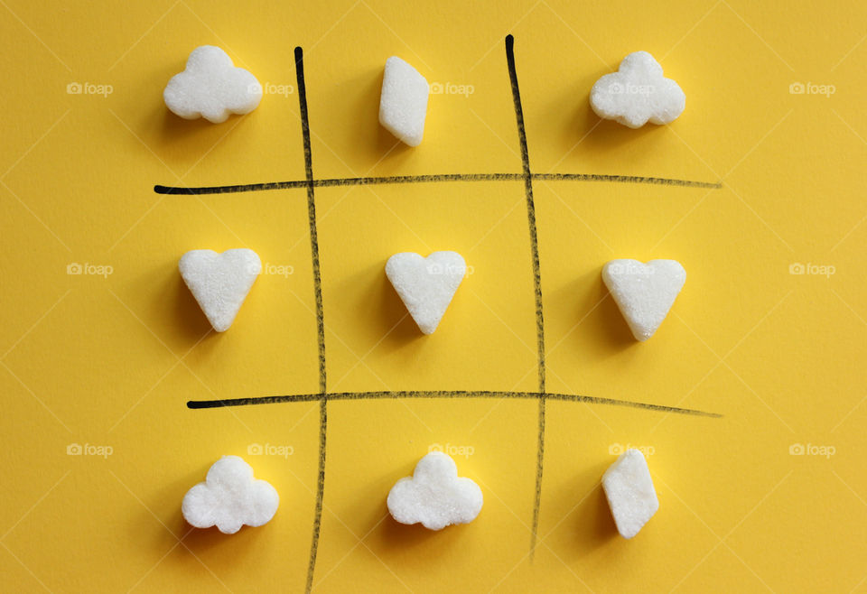 Tic tac toe game with sugar shaped pieces, love is the choice.