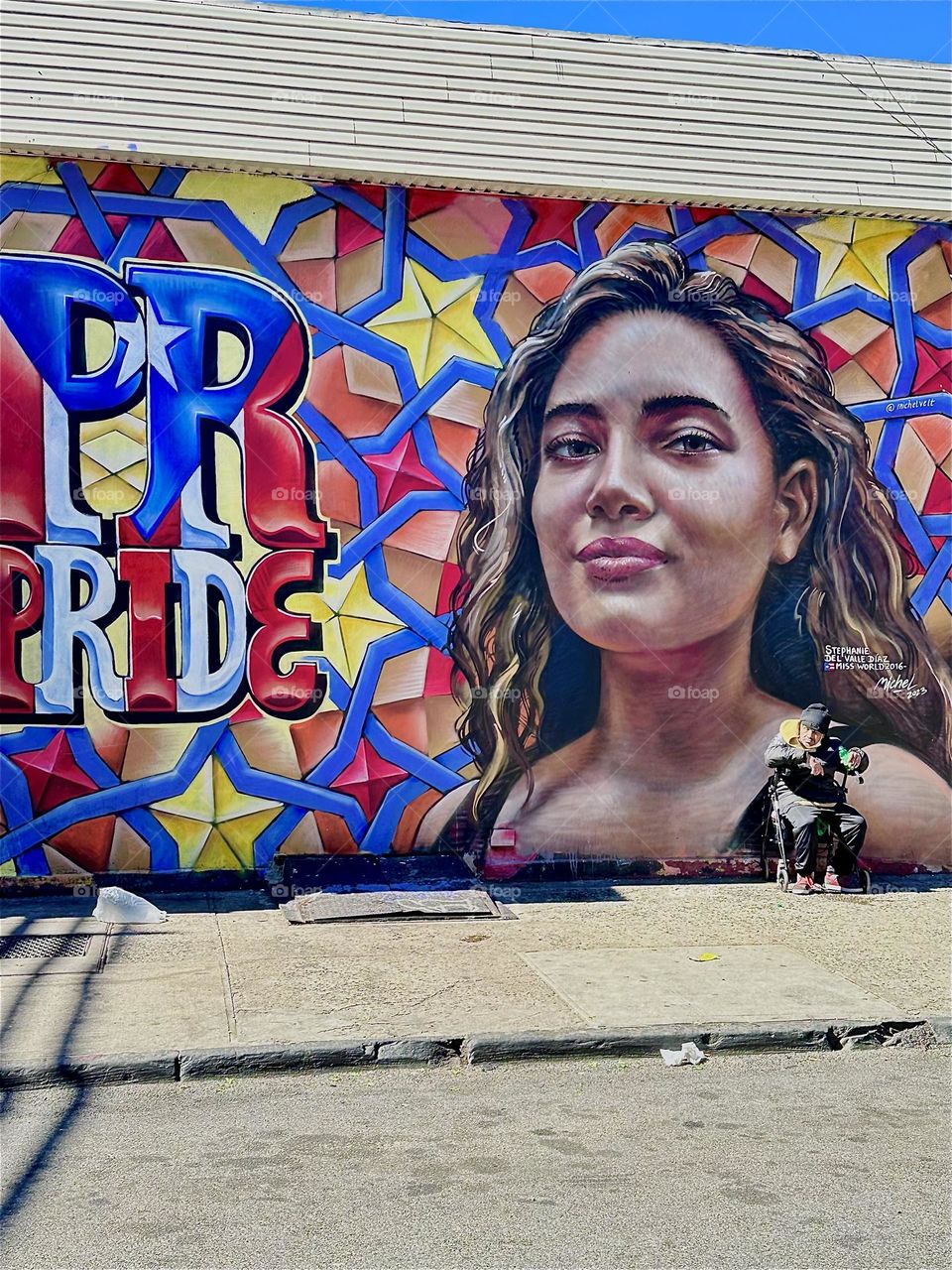 This is one part of a beautiful art mural on „Jefferson Street“ right off “Broadway“ in „Bushwick“, Brooklyn showing a young Latin lady next to a star and floral pattern and the word „PRIDE“. 2024. Hypnotic Productions