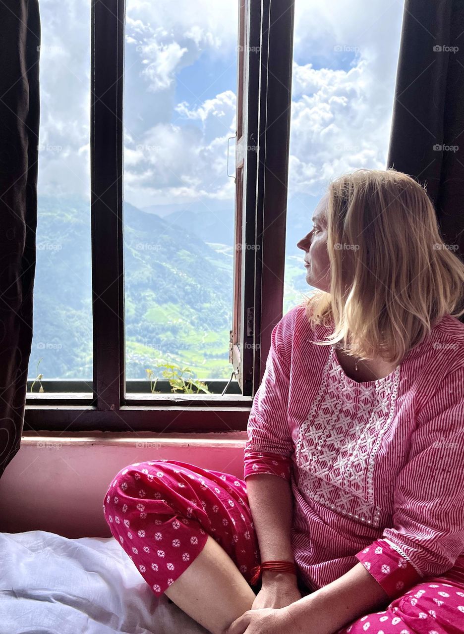 Woman sits near the window with mountain view 