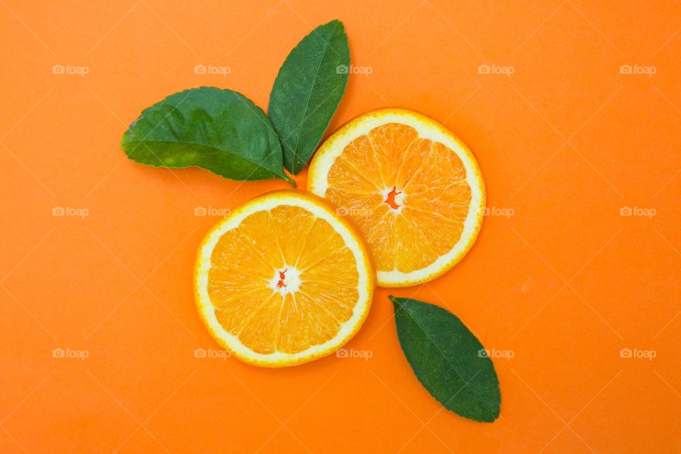Object - Sliced orange and leaves on orange background