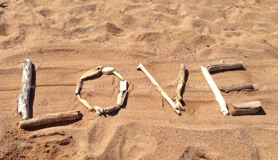 Love written with driftwood on the beach