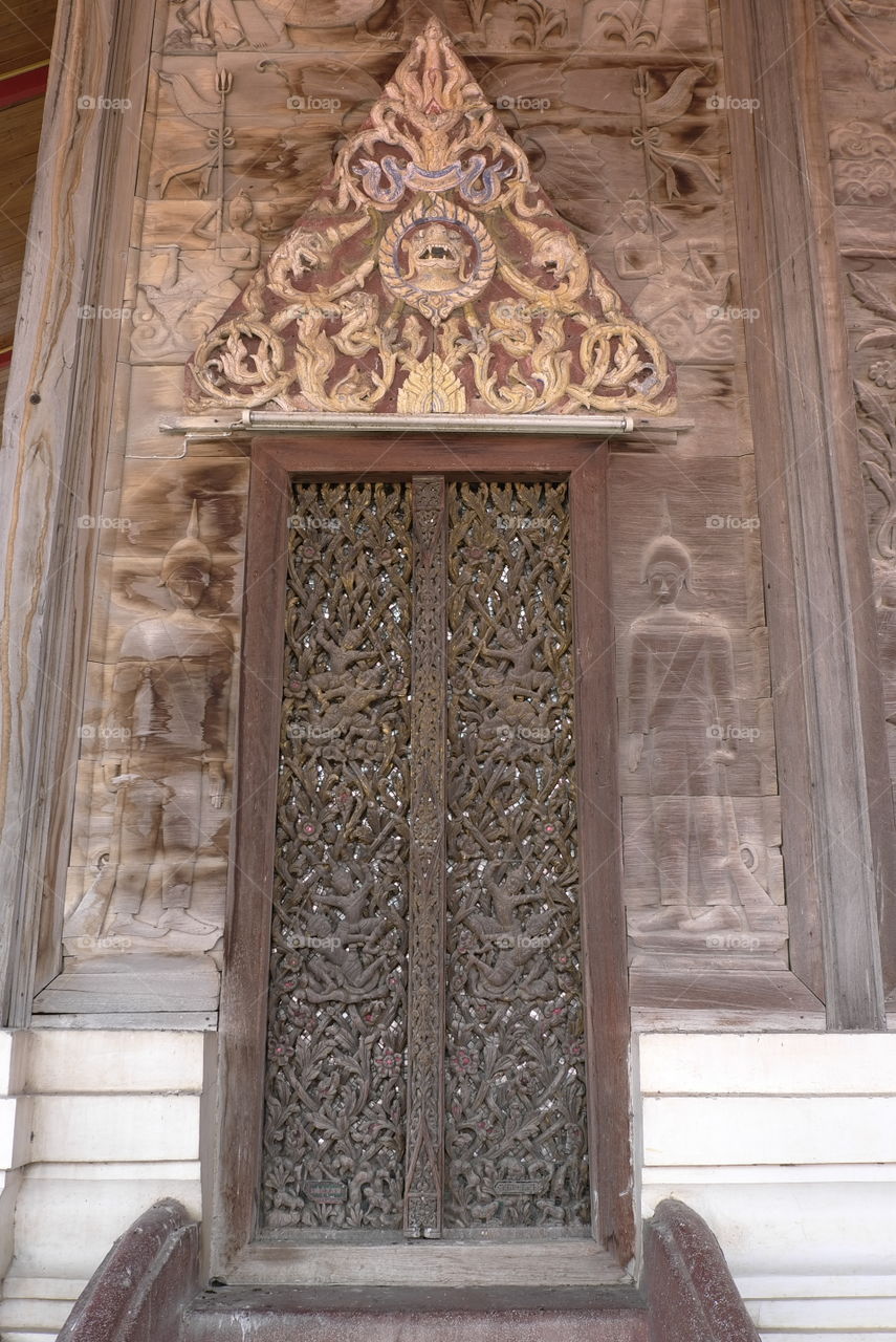 Ancient Thai carvings wood door in a temple