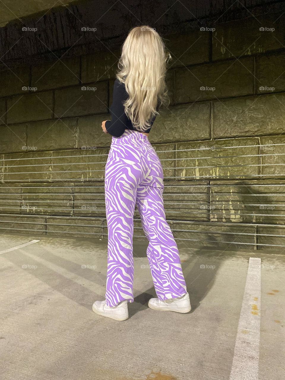 Blonde girl with funky purple and white pants in urban setting 