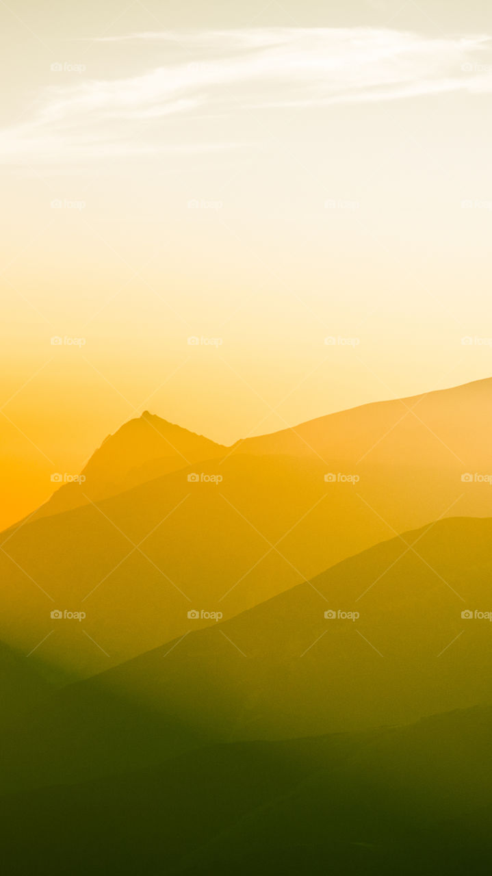 An inspiring mountain landscape. Tatry mountains in Slovakia. A beautiful wallpaper for smartphone screen. Warm summer haze, abstract gradient with perspective.