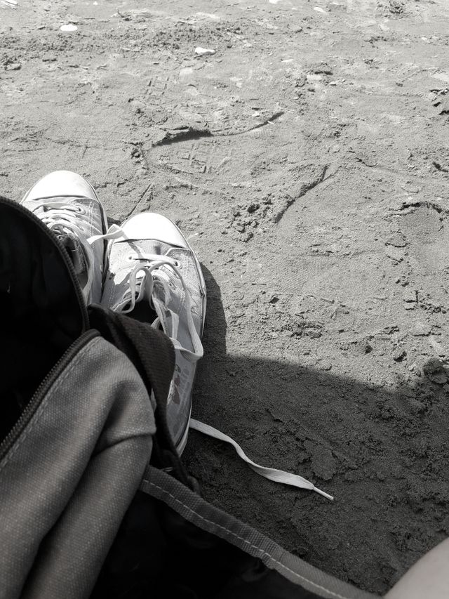 a monochrome pictur with shoes ans sea