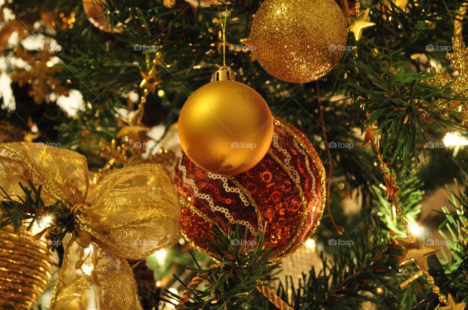 Golden orange Christmas tree decorations and ornaments close up 