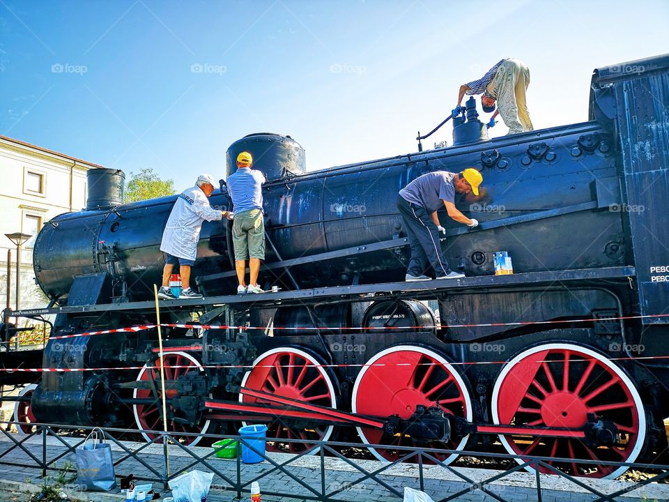 Workers repairing an old locomotive