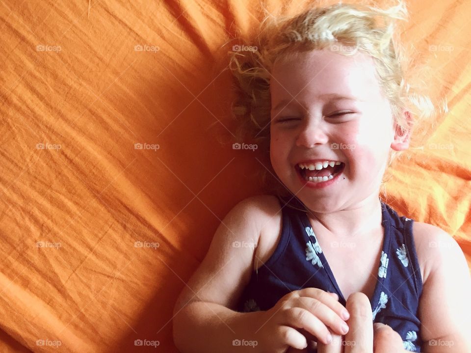 Cute happy girl lying on bed