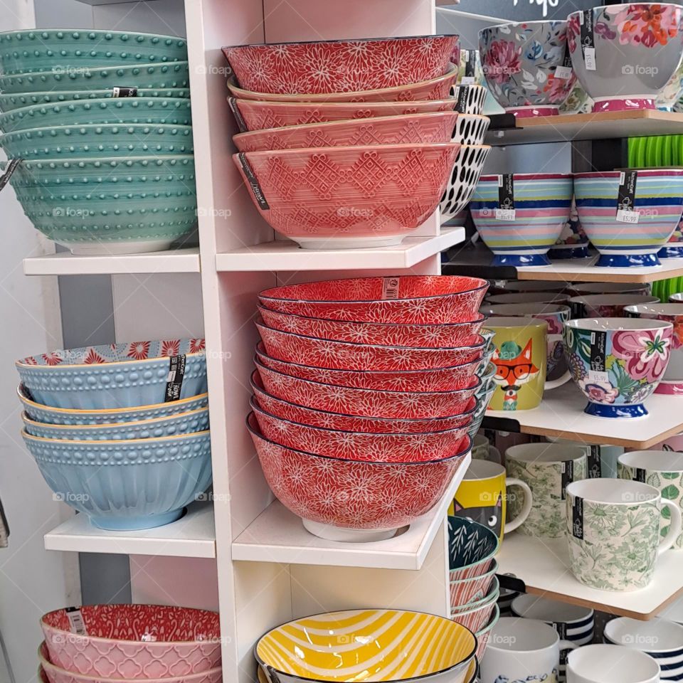 colourful display of dishes and mugs. shop shelves.