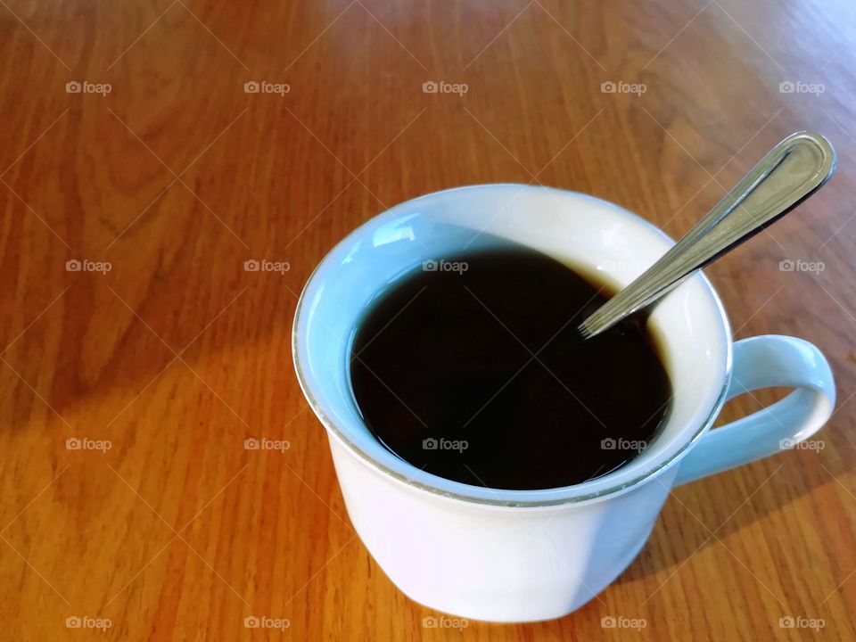 A cup of black coffee on wooden table.
