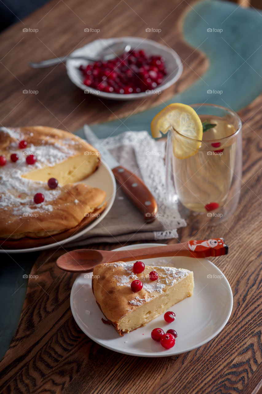 Cheesecake with cranberries and sugar on wooden background