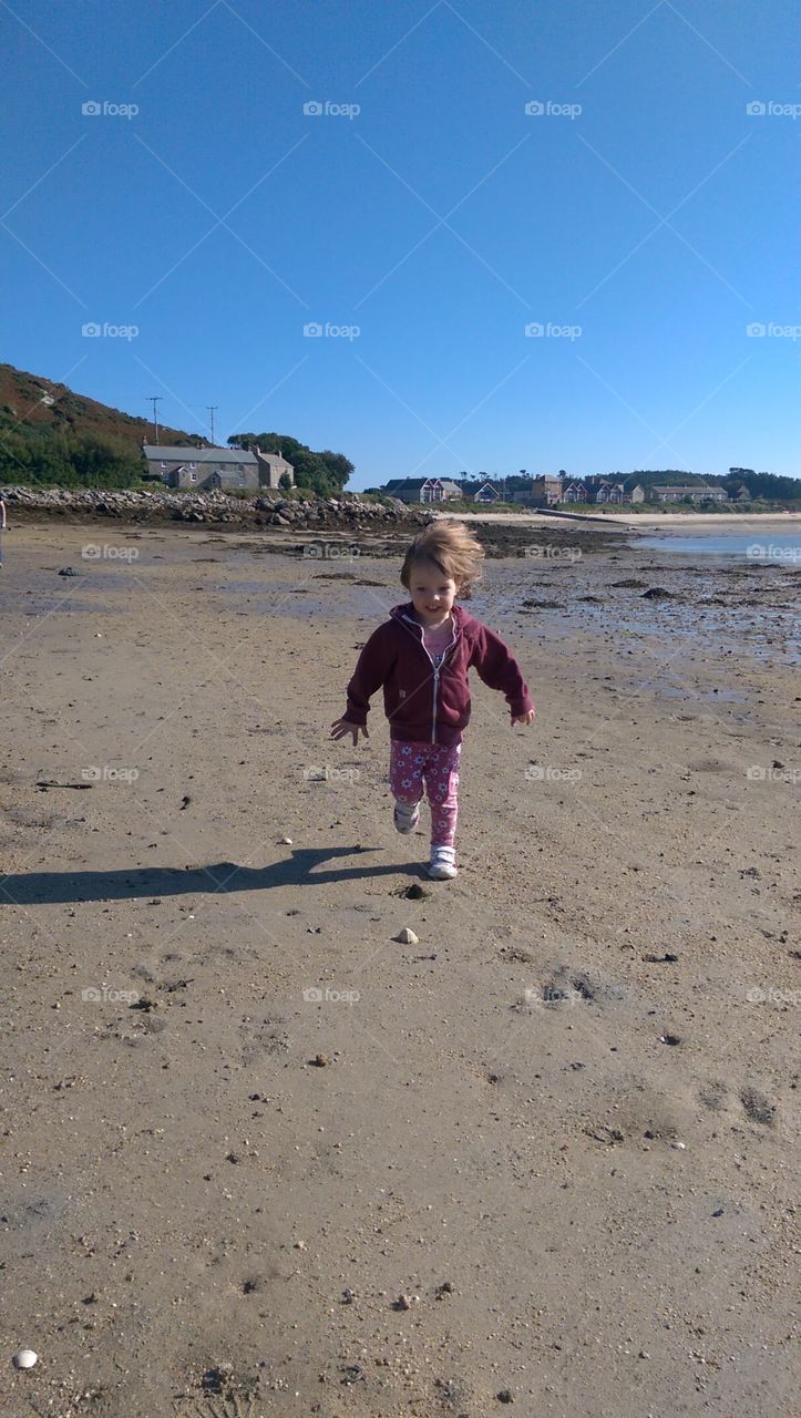 child running down shore in morning light