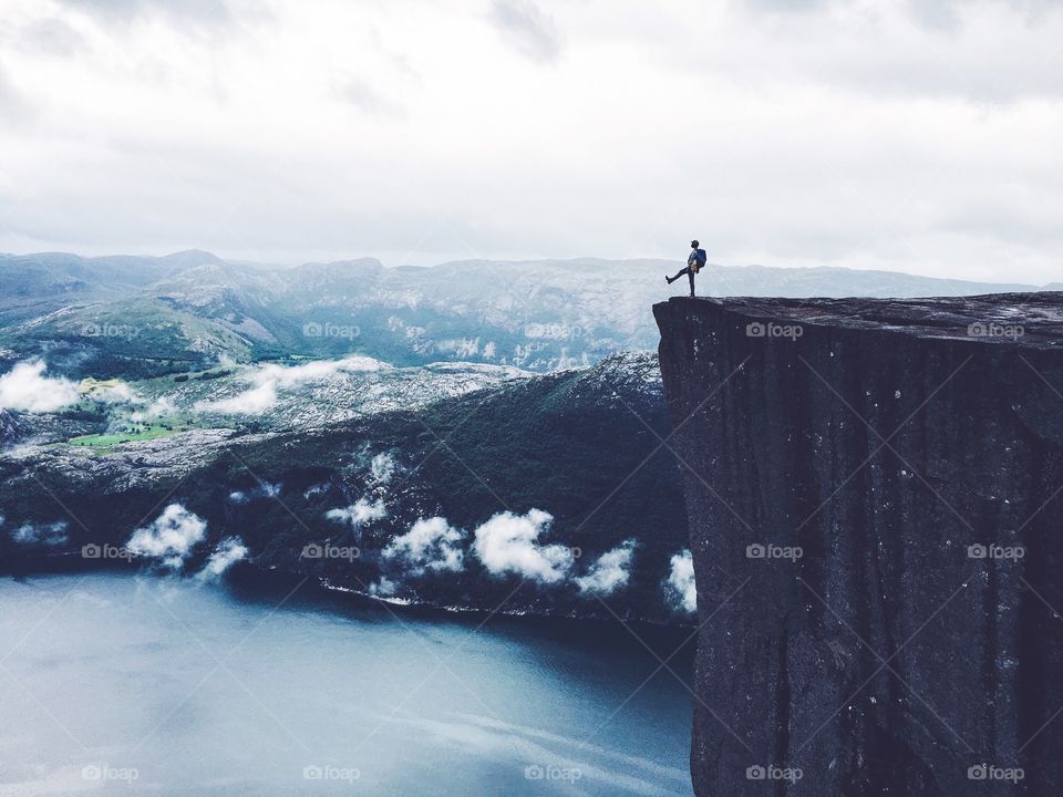 Silhouette stepping from the edge of Prekestolen rock. 