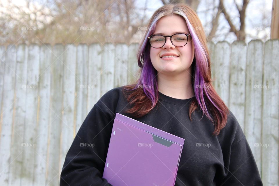 Teenager student with purple five star folder 