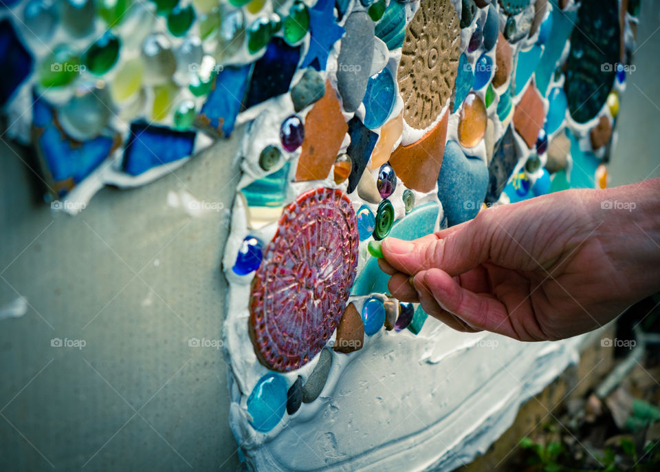 Hand putting mosaic piece in place
