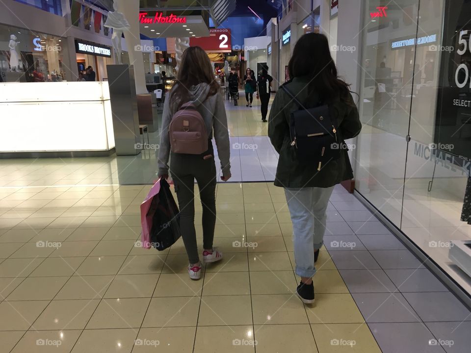 Two teenage girls shopping at a city mall