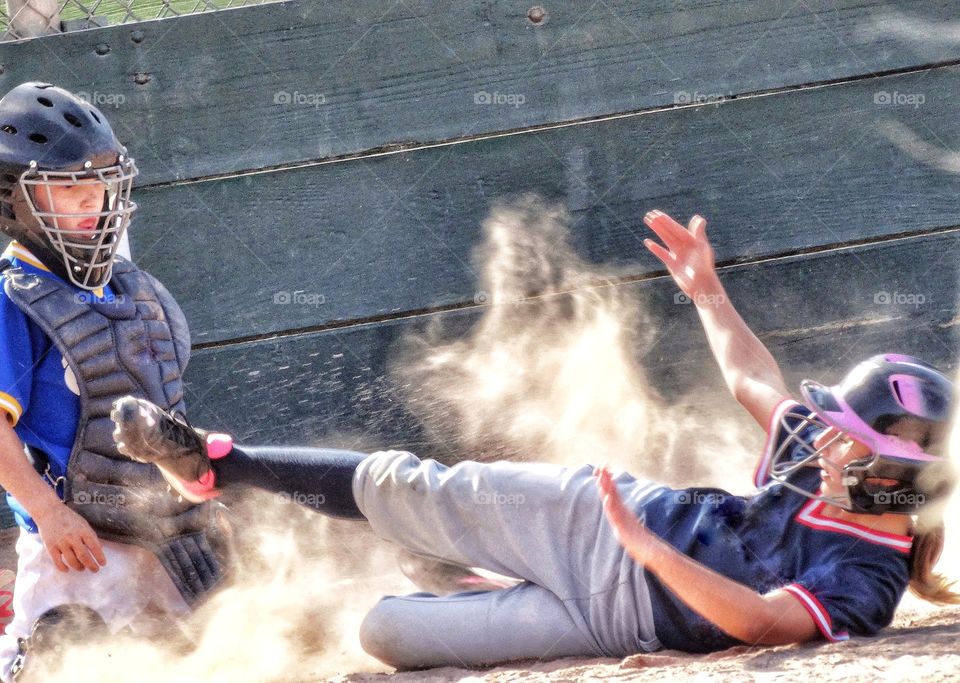 Girl Sliding Into Home Base In Little League Baseball