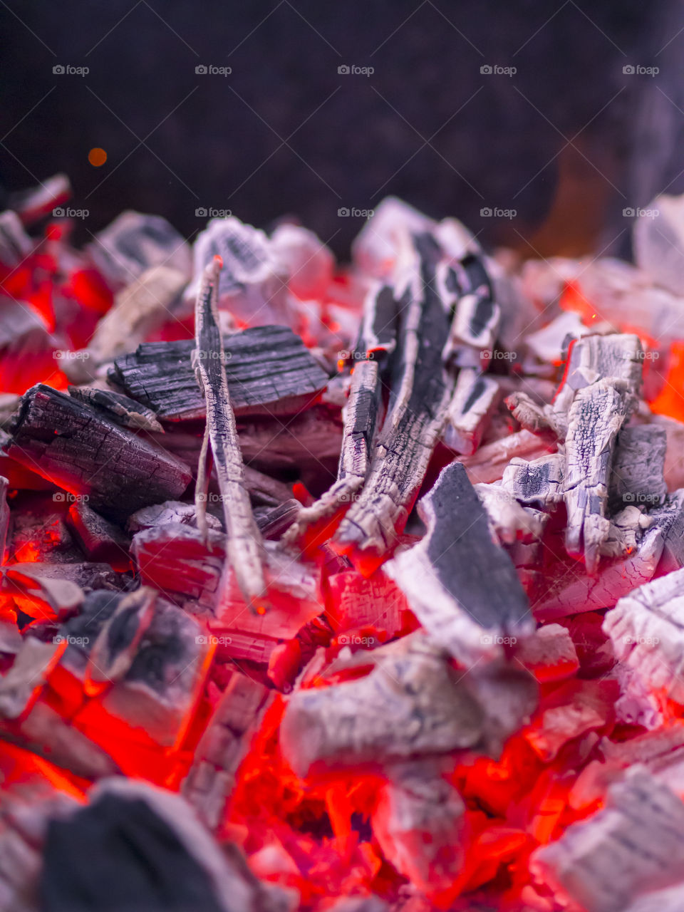 A burning fire burns to coals with a bright red-yellow flame for roasting meat.