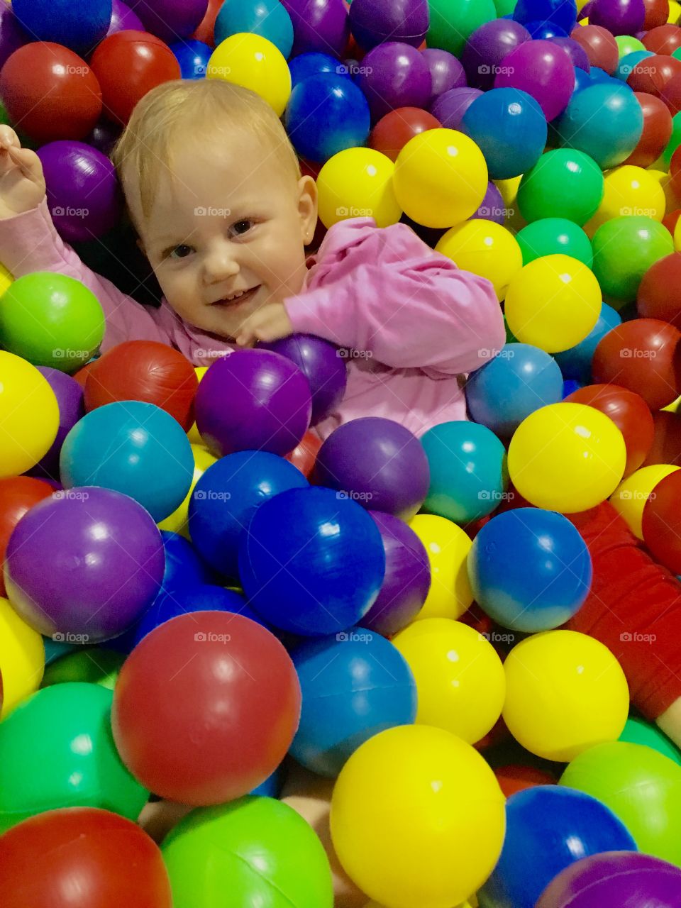 Uma menininha se divertindo na piscina de bolinhas! Que fofura / doçura de sorriso...