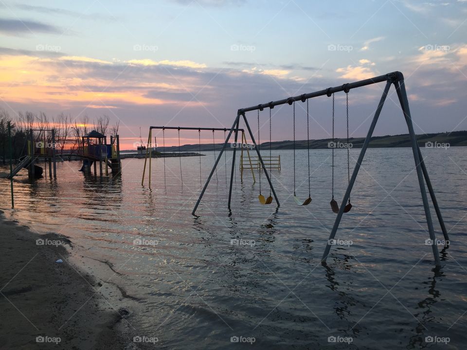 Flooded playground with beautiful sunset. 