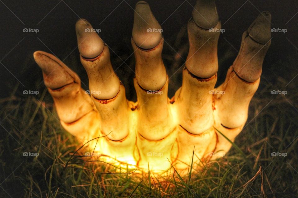 Glowing hand coming up from the ground 