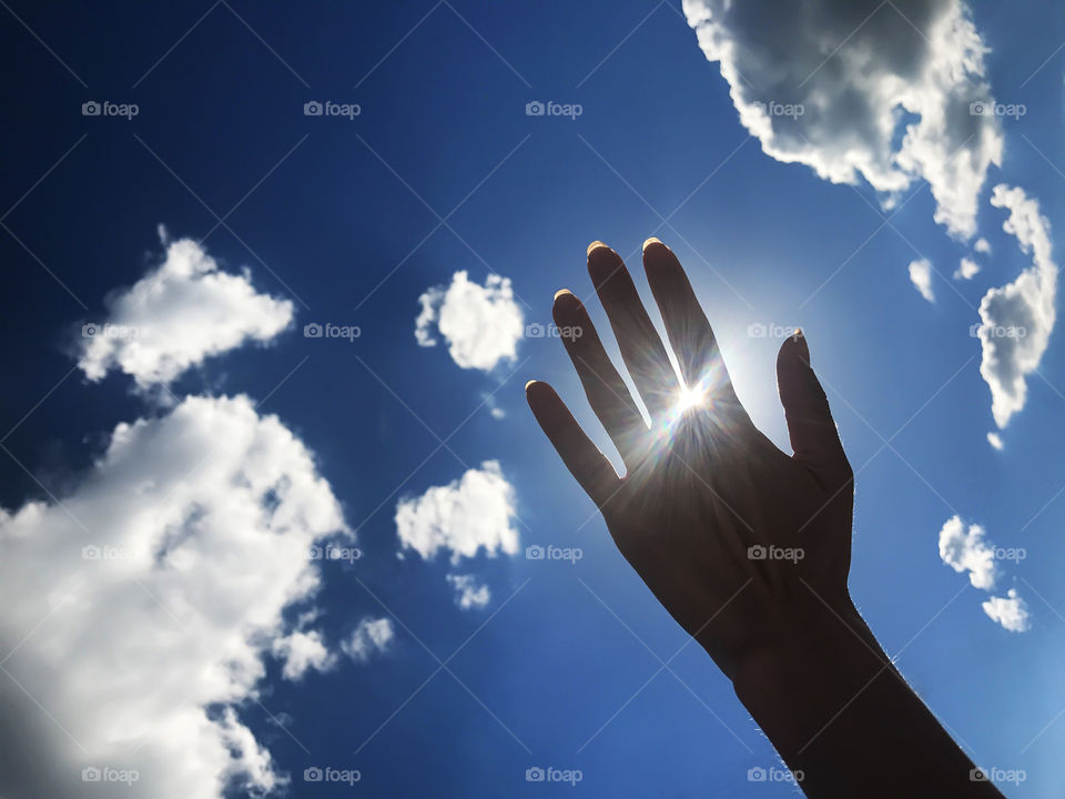 Hand on sky background 